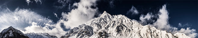 Landschaftsaufnahme der verschneiten Alpen in Samnaun, Schweiz als Panorama-Photographie in Color