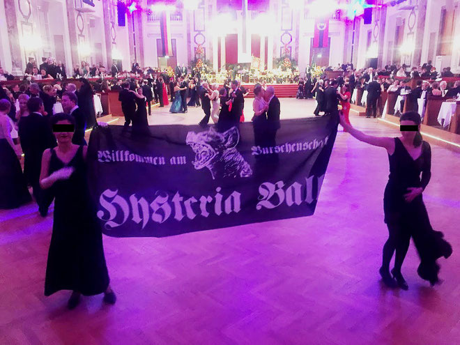 Nogle aktivister kunne udklædt i elegante aftenkjoler smugle sig ind til festen og udrulle et banner med teksten : ”Willkommen zum Burschenschaft – Hysteria Ball”  