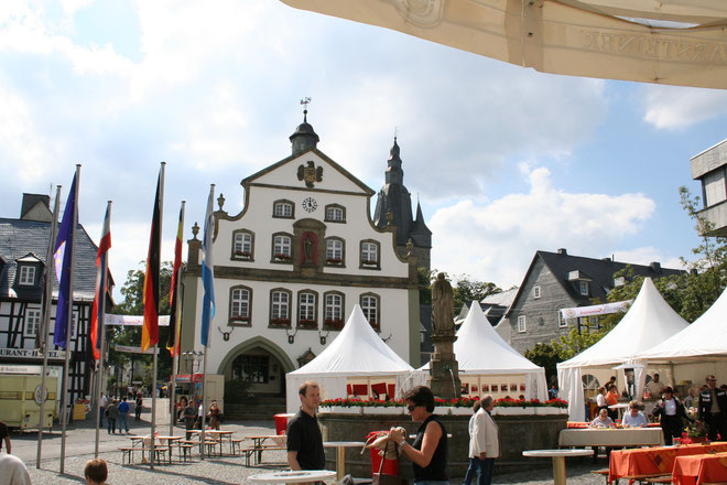 Irgend einen Grund zum Feiern finden die Briloner immer: Marktplatz mit Petrusbrunnen, genannt "Kump", Rathaus (und Propsteikirchturm im Hintergrund)