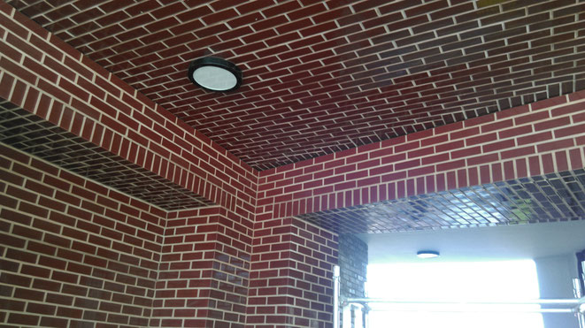 Installation of BrickCloak cladding system adopting burgundy glazed brick slipsdding Panels