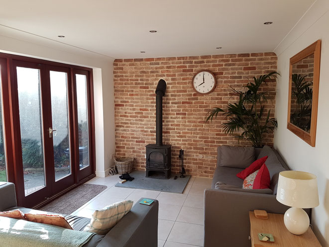 Olde Coach House brick slip wall and wood burning stove