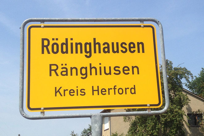Ortsschild aus Rödinghausen mit plattdeutscher Bezeichnung Ränghiusen