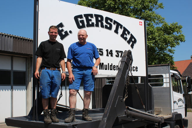 Das Team von Gerster Recycling steht auf einem Industriegelände. Im Hintergrund ist der Familienbetrieb und grosse rote Abfallcontainer mit dem Logo von Gerster Recycling zu sehen. Das Bild zeigt kompetente Fachpersonen.