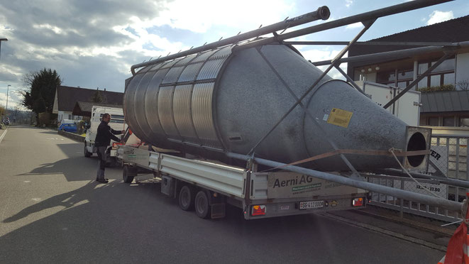 Ein weisser Lastwagen von Gerster Recycling steht am Abbruch und der Demontage von Industrieanlagen. Es ist ein Kran mit Greifer und Logo von Gerster Recycling zu sehen. Das Bild zeigt einen Transport und Muldenservice.