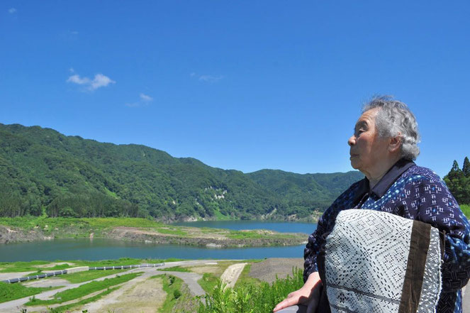 古いこぎんを携え、かつての収集の地であり、ダム湖の底に沈んだ西目屋村砂子瀬を訪れた昭子さん（2016年）