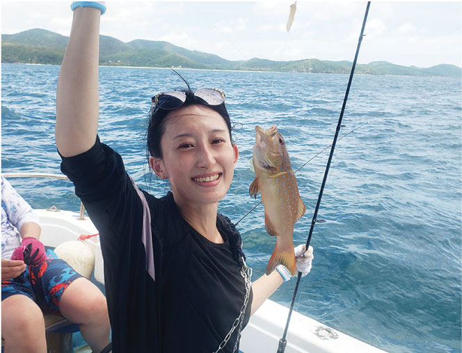 海釣りツアーで魚を釣り上げた女性