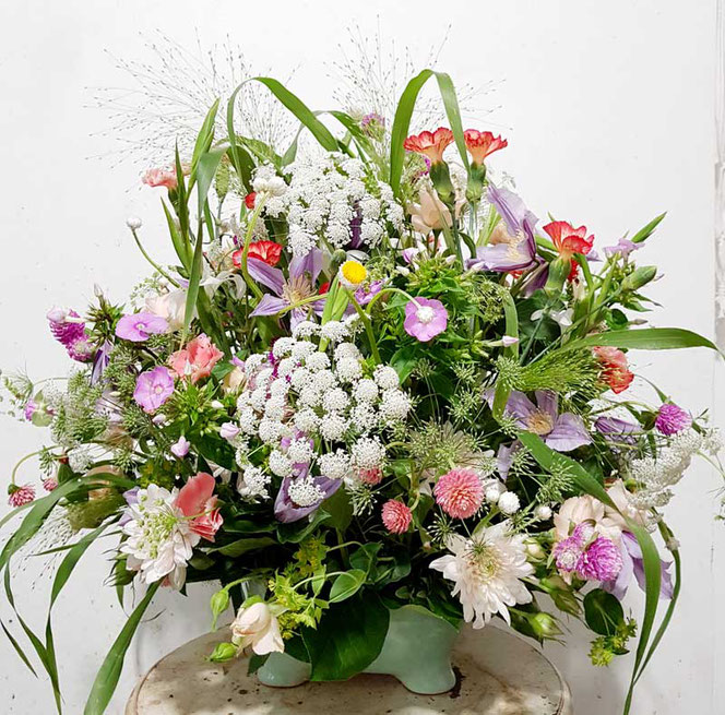 Blumengesteck mit Clematis und anderen Wiesenblumen in lila, rosa und weiß