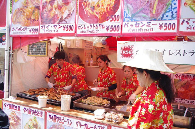 活気のあるレストラン。パッタイ（タイの焼きそば）を鉄板で炒める調理光景。「第14回 タイ・フェスティバル2013年 東京・代々木」の会場写真