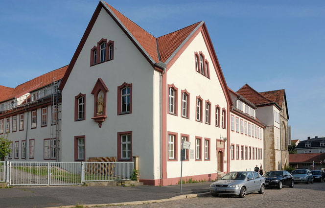 Ein Panoramaansicht des Martin-Luther-Gymnasiums, auf eine Ecke zu fotografiert. Vorne rechts parken Pkw. Links ist das Gitter zur Einfahrt in einen Hof.