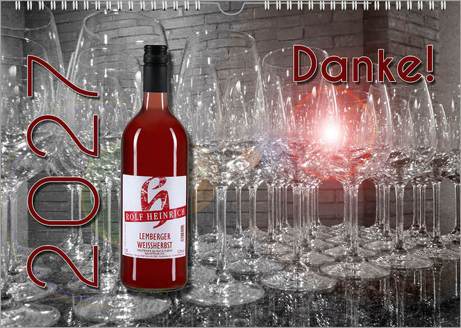 Es ist der premium-personalisierte Weinkalender. Vor einem Hintergrund voller leerer gestapelter Weingläser ist vorne links eine Rotweinflasche. Links daneben ist eine große Jahreszahl und rechts ist ein rostroter Lichtrefelx.