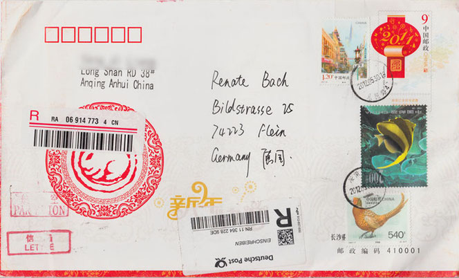 Auf einem weißen Briefumschlag ist in der Mitte die handschriftliche Adresse. Rechts sind drei Briefmarken. Links ist ein kreisrundes, rotes Emblem und der Absender. Es ist ein Brief aus China.