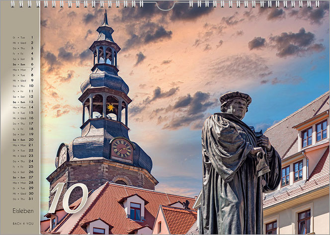 Es ist ein verfremdetes Foto auf diesem Luther-Kalender-Monatsblatt. Links ist ein riesiger Glockenturm, rechts ist das Luther-Denkmal. Am linken Rand ist das Kalendarium auf goldenem Grund.