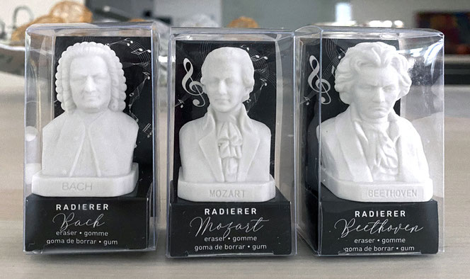 Nebeneinander stehen drei winzige Komponisten-Radierer in ihrer Klarsichtverpackung. Es sind Bach, Mozart und Beethoven.