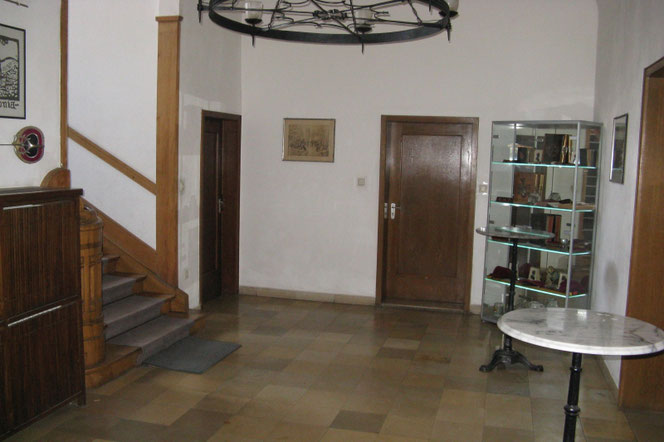 Das Foyer im Eingangsbereich mit Stehtisch und Vitrine mit Archivgegenständen