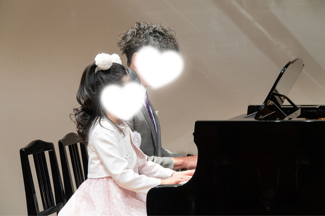 発表会で親子が連弾演奏している様子