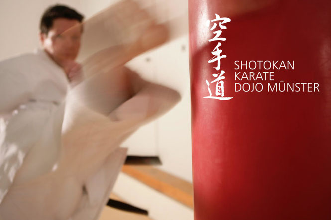 Karate-Meister tritt mit einem Roundhouse-Kick vor einen Boxsack.