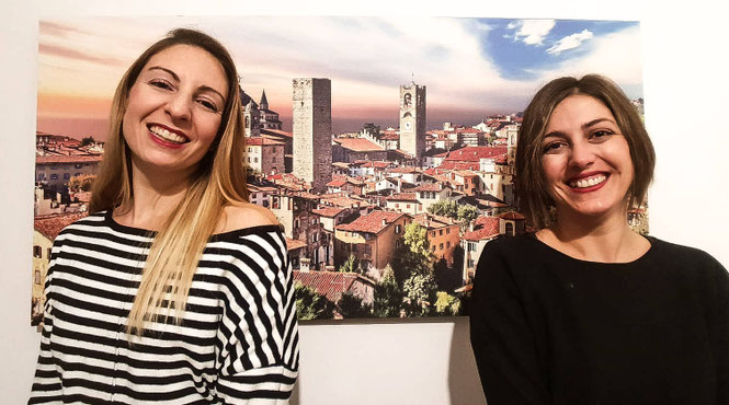 due signore che sorridono con sfondo di Bergamo