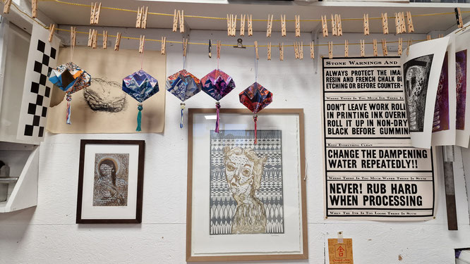 Artsy gallery wall with origami and prints and clothes pegs