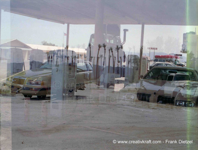 Desert Center, California: double exposure - last picture on the film. Foreground: old gas station, center: circle of palm trees, background left: store, background right: cafe, 44325 Ragsdale Rd, Desert Center, CA 92239, United States, 4/1993