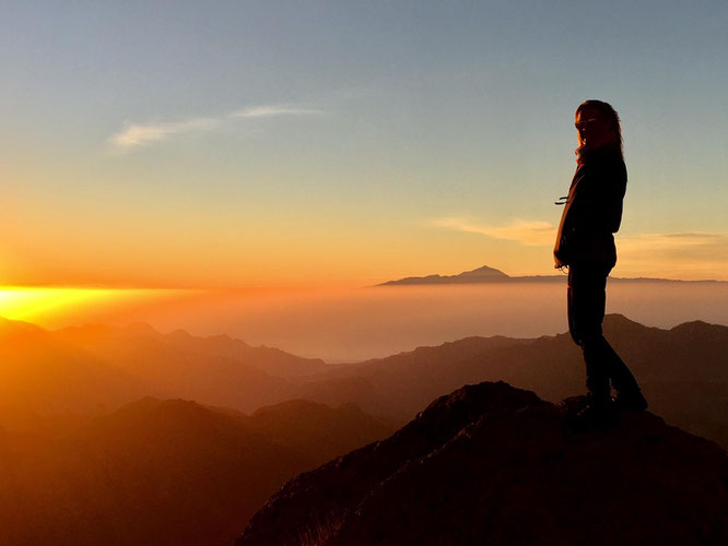 Person auf dem Berg mit Weitsicht im Sonnenuntergang  - Jahrestraining