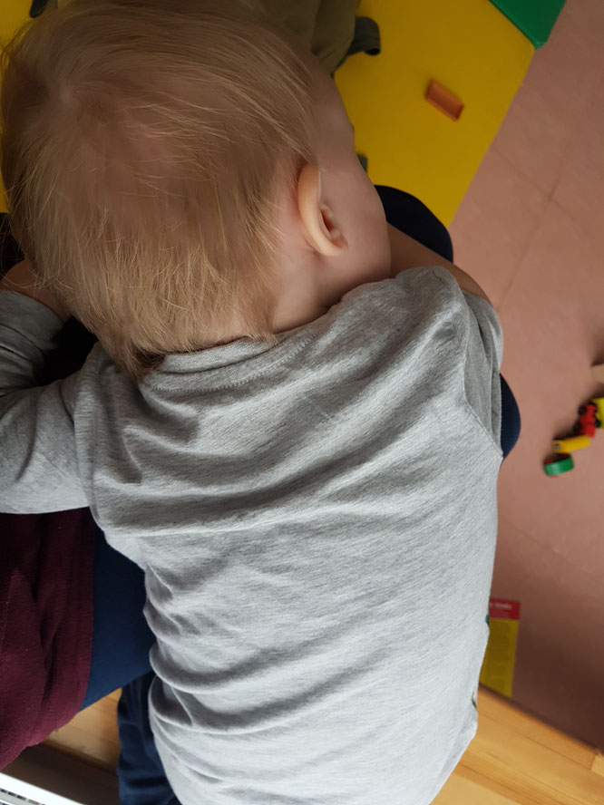 Kleinkind in Kita auf Jana Mama Patschehands Schoß.