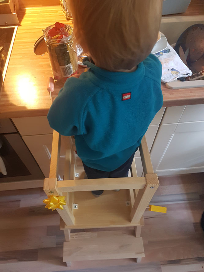 Kleinkind im Montessori-inspirierten Learning-Tower in der Küche im Hause Patschehand.