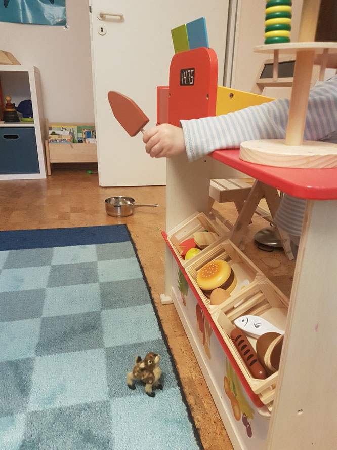 Kleinkind spielt mit Kaufmannsladen im Kinderzimmer. Tipps für den Kauf auf Mama-Blog Patschehand.de.