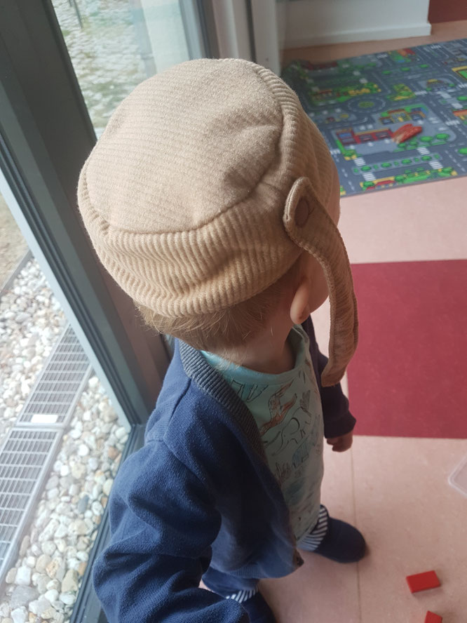 Kleinkind spielt mit Spielküche und Obst- und Gemüsekorb in Kita während der Eingewöhnungsphase.
