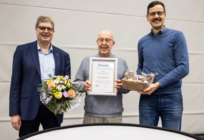 VfL-Präsident Carsten Brokelmann (l.) und Geschäftsführer Justin Moradi (r.) ernannten Rudi Steinkamp bei der Mitgliederversammlung am 12. März 2026 zum Ehrenmitglied.