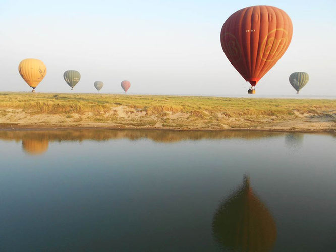 Hot air balloons over river in Bagan