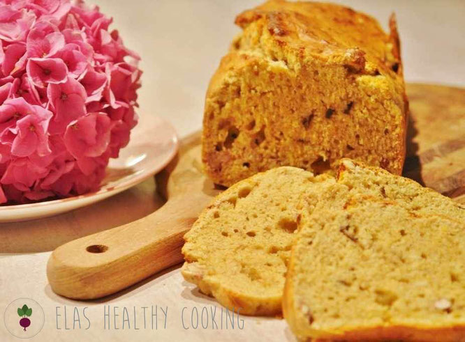 Bananen-Walnuss-Frühstücksbrot auf Holzbrett mit Hortensie im Hintergrund