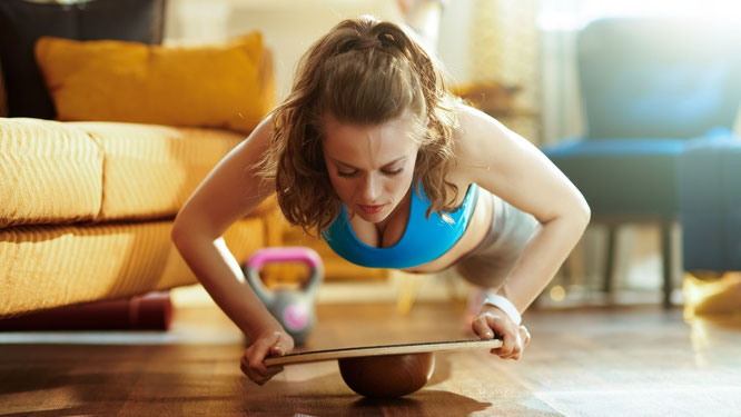 Frau bei Balance-Board-Übung