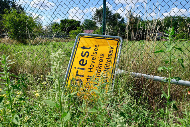 Ortsschild Briest umgefallen im Unkraut, Brandenburg