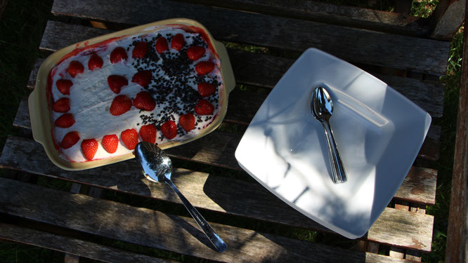 Das Erdbeer-Tiramisu wartet auf einer alten Gartenbank darauf verspeist zu werden