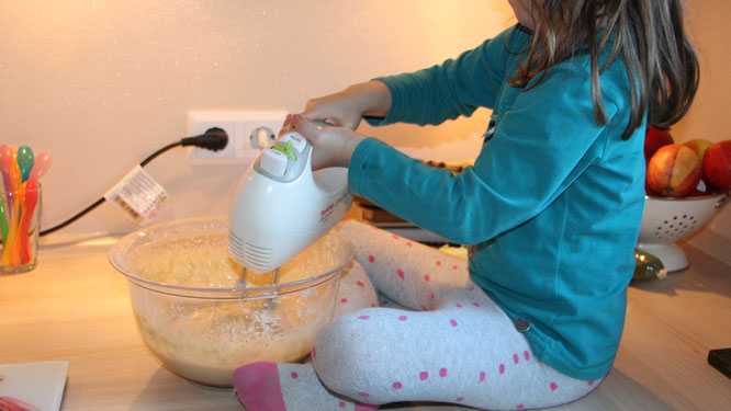 Unsere Kleine rührt mit einem Handrührgerät den Waffelteig