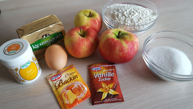 Zutaten für einen Apfel-Streusel-Kuchen: Äpfel, Butter, Mehl, Zucker, Vanillezucker, Backpulver, Zimt, Ei