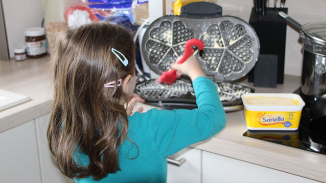 Unsere Kleine fettet das Waffeleisen ein
