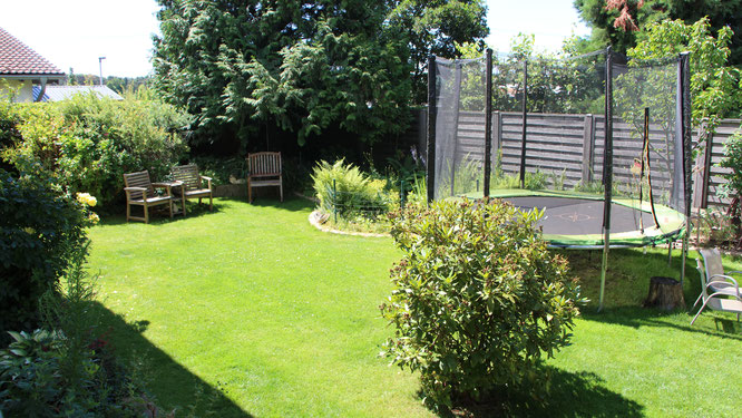 Blick in unseren Garten mit Schattenbeet, Teich und Trampolin