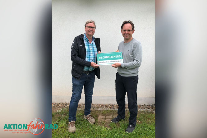 Ulrich Fillies und Michael Kreil mit dem Schild  "#SCHOOLBIKERS - Diese Schule ist fahrradfreundlich"