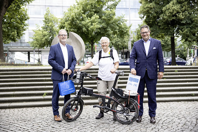 Patrick Döring (re., Vorstandsvorsitzender Wertgarantie) und Georg Düsener (Bereichsleiter Vertrieb Bike Wertgarantie) begrüßen Dr. Marta Binder bei ihrem Besuch in Hannover. Foto: S. Krahforst/Wertgarantie 