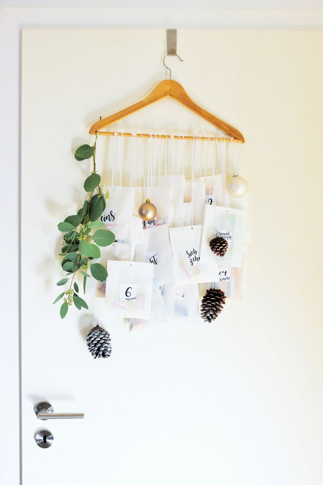 Bild: DIY Adventskalender Idee mit Kleiderbügel und Papiertüten, inklusive Freebie Zahlen zum ausdrucken im angesagten Lettering-Style; gefunden auf www.partystories.de
