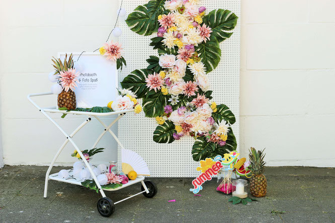 Bild: DIY Photobooth -So einfach kannst Du eine schöne Fotoecke samt Hintergrundwand im tropical Style aus Seidenblumen und Monstera Blättern selbst gestalten, von Partystories.de in Kooperation mit Depot