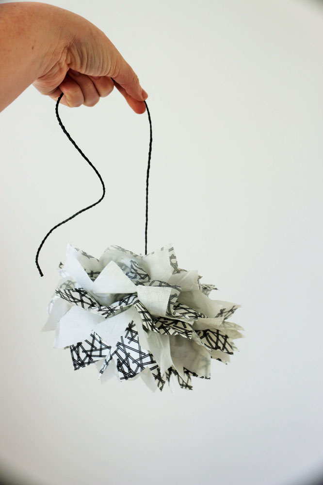 Bild: DIY PomPoms aus Servietten basteln - Mit dieser Schritt-für-Schritt Anleitung kannst Du PomPoms aus Servietten als Deko für die Party oder Hochzeit ganz einfach selber basteln; gefunden auf www.partystories.de