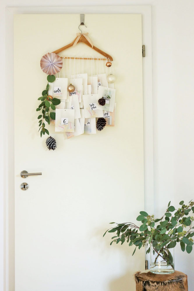 Bild: DIY Adventskalender Idee mit Kleiderbügel und Papiertüten, inklusive Freebie Zahlen zum ausdrucken im angesagten Lettering-Style; gefunden auf www.partystories.de
