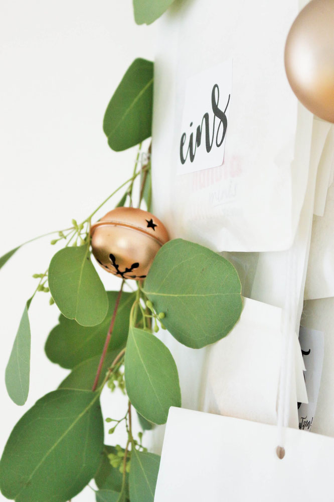 Bild: DIY Adventskalender Idee mit Kleiderbügel und Papiertüten, inklusive Freebie Zahlen zum ausdrucken im angesagten Lettering-Style; gefunden auf www.partystories.de