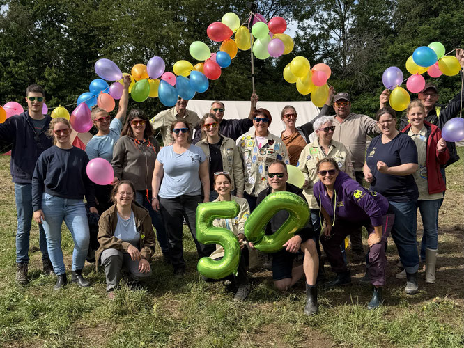 Gruppebild der Leitungsrunde mit Luftballonen und einer großen grünen 50