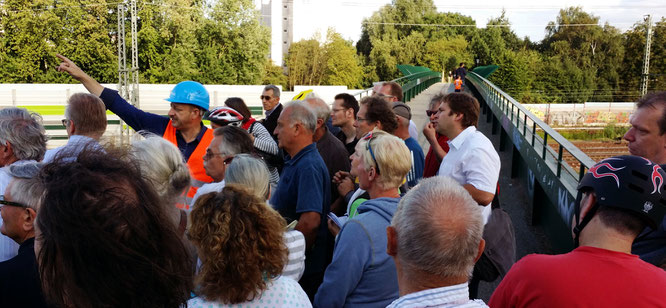 Auf der Brackstraßenbrücke lässt sich Michael Weinreich (MdHB) zusammen mit rund 50 Teilnehmern die Baustelle vom Projektleiter Martin Steinkühler (DEGES) erklären
