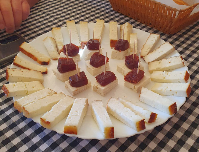 heller-rohmilch-ziegenkaese-in-haeppchen-auf-einem-teller-einige-stuecke-mit-guaven-marmelade