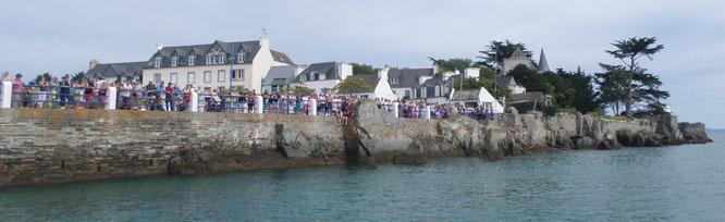 La foule est nombreuse, accoudée aux rambardes du quai.