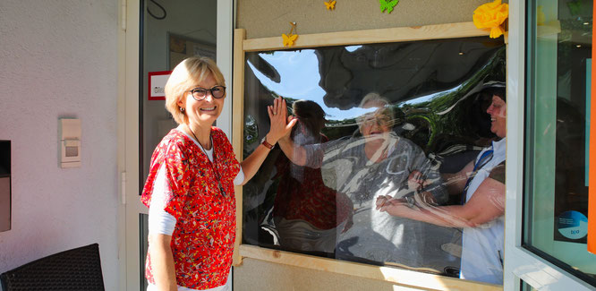 Dank einer Holzkonstruktion mit Plexiglasscheibe kann Karin Steinfeld aus Quierschied ihre Mutter Agnes Sitzmann wieder regelmäßig besuchen.